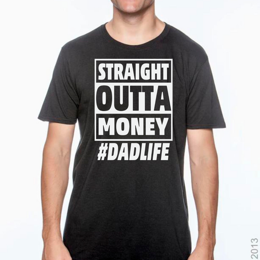 Image of a T-shirt with the phrase ‘Straight Out of Money #DadLife’ in bold, eye-catching lettering. The design humorously reflects the financial jest of fatherhood where dads spend generously on their kids. The shirt is displayed in multiple colors: black, red, yellow, gold, blue, and green, catering to various personal styles. This shirt offers both comfort and a funny twist on the everyday life of dads.