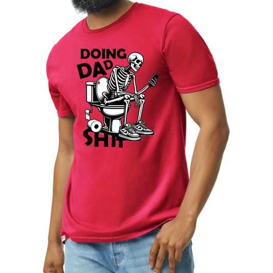 Image of a T-shirt depicting a humorous graphic of a skeleton sitting on a toilet while using a phone. The text ‘Doing Dad Sh*t’ is prominently displayed above the graphic. The T-shirt is shown in four color options: vibrant red, classic gray, bold blue, and fresh green, highlighting its availability for different preferences. A perfect blend of comfort and dad-style humor, suitable for various casual occasions.