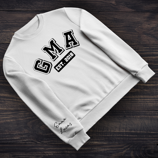 A cozy sweatshirt with “GMA Est. [year]” printed on the chest and customizable sleeves displaying grandchildren’s names. Perfect for grandmothers, featuring a soft, warm fabric and a personalized touch.