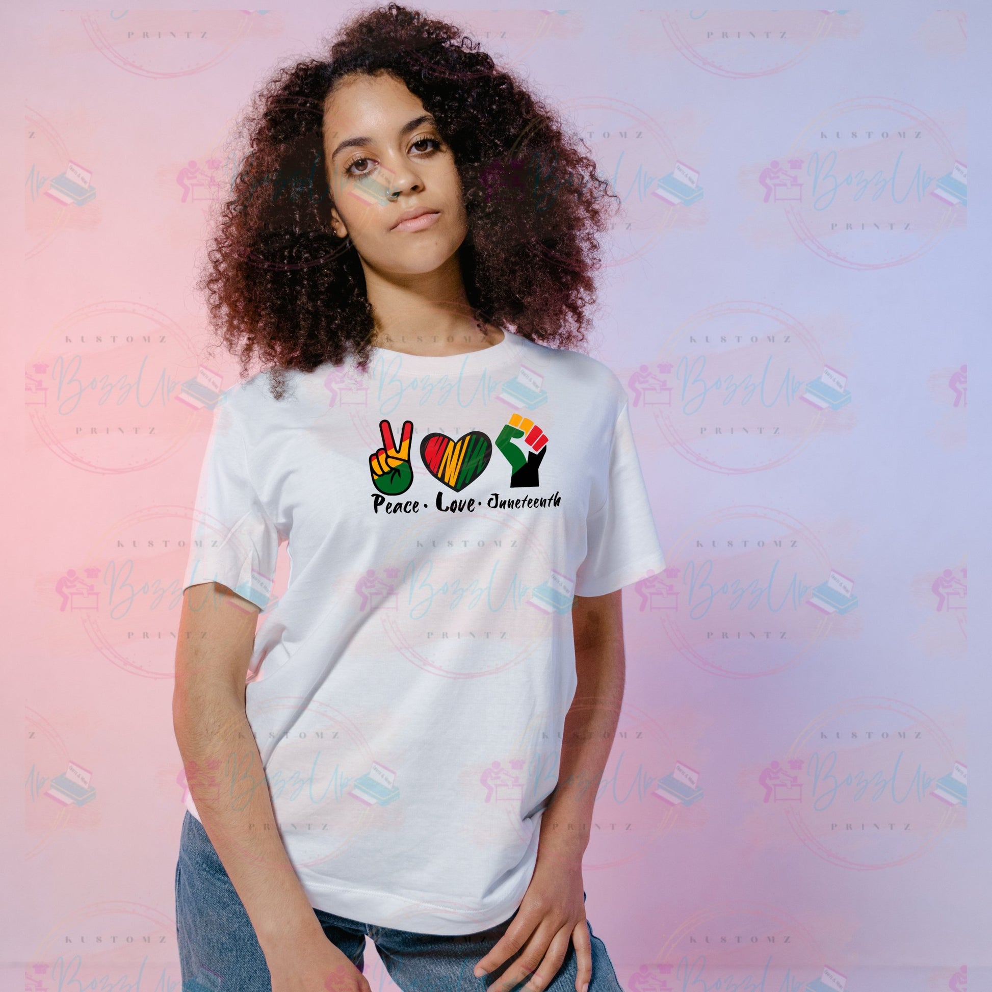 A t-shirt featuring the words “peace,” “love,” and “Juneteenth” in vibrant red, yellow, black, and green colors representing African American culture. Each word is enhanced with a symbolic icon: a peace sign over “peace,” a heart over “love,” and an empowerment fist over “Juneteenth.” This design celebrates cultural pride and unity, ideal for Juneteenth commemorations and everyday wear. Bozzup Kustomz